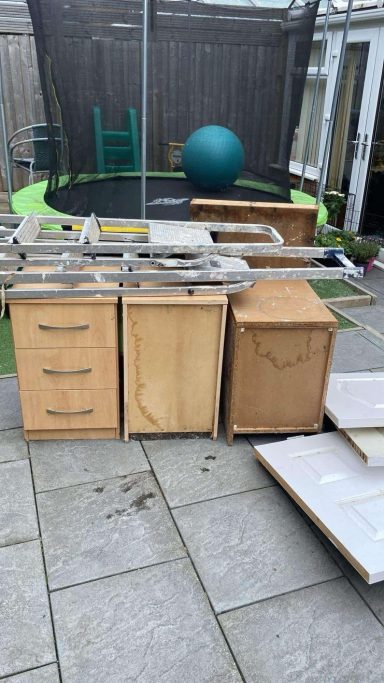 Wooden furniture, including drawers and cabinets, placed outdoors near a trampoline.